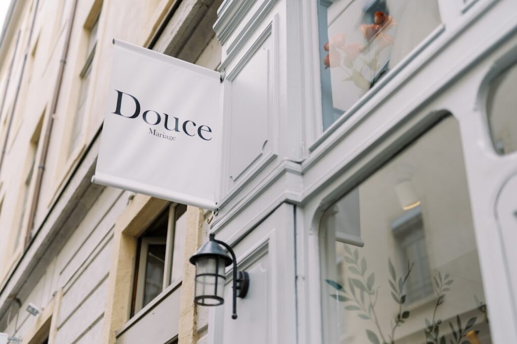 Façade historique de la boutique de robes de mariée à Lyon avec la pancarte visible, présentant notre collection de robes sur mesure