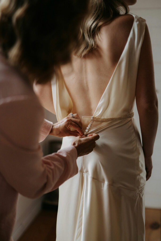 Détail de robe fluide, matière naturelle et lumière douce.